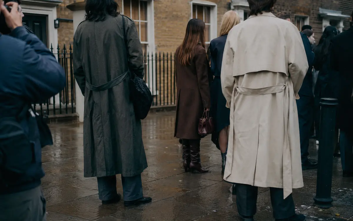Show-goers photographed on the pavement outside a London Fashion Week venue on an overcast September afternoon.